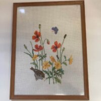 Indrammet broderi med gråspurv og blomster